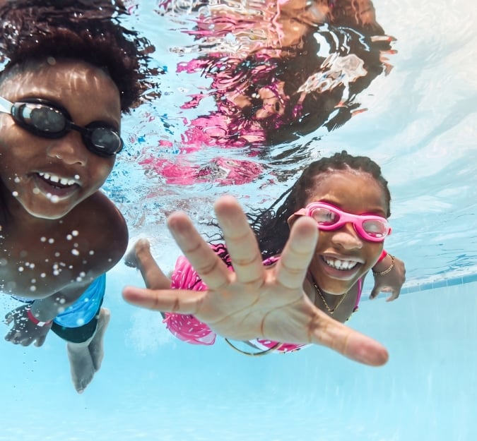 Kids swimming underwater with swimming goggles on