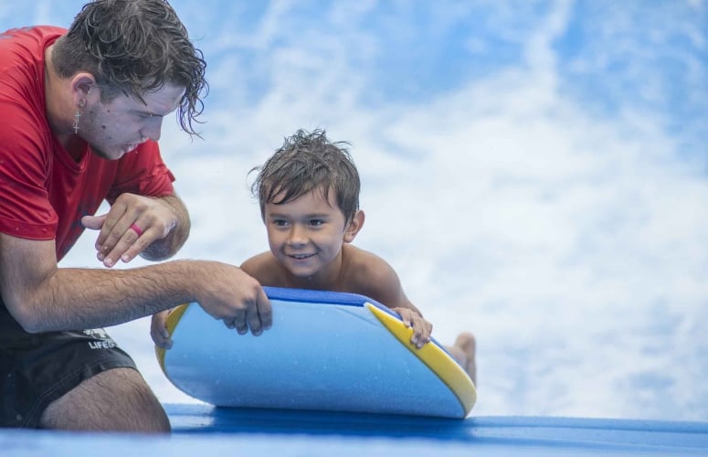 Boy receiving instruction on FlowRider