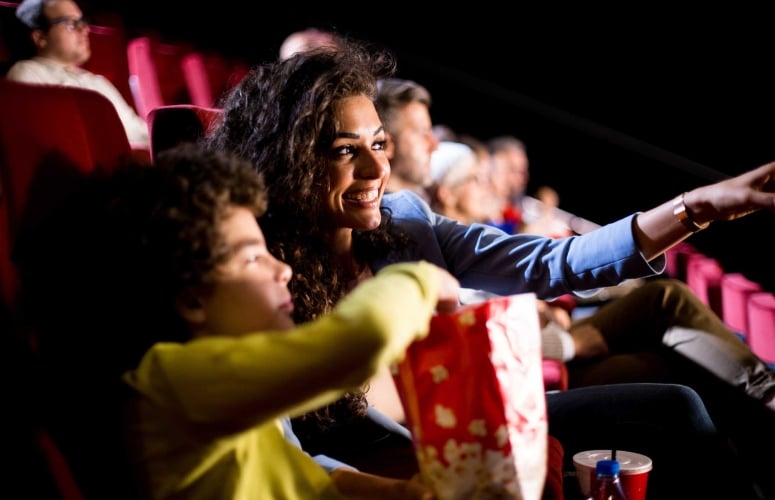 Happy woman enjoying with her son at the cinema