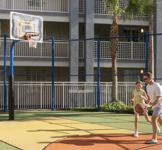 A dad and his daughter playing one on one basketball